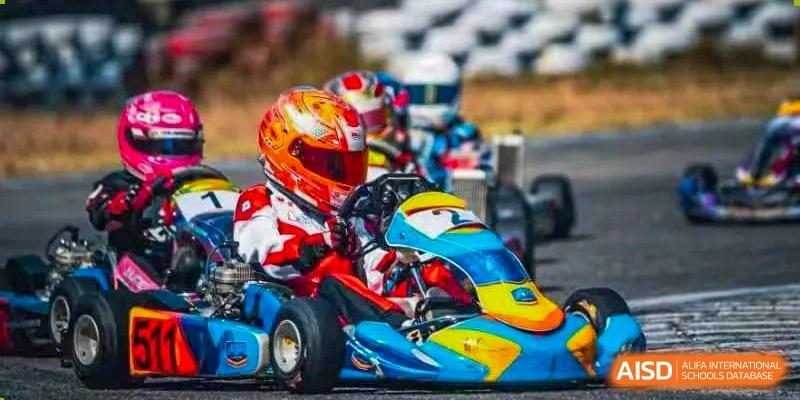 A student from Zhuhai Qiao International School racing a colorful go-kart while wearing a helmet, showing participation in motorsports or an adrenaline activity.