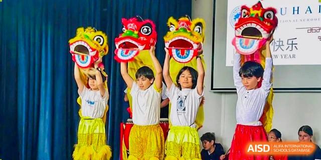 Students at Zhuhai Qiao International School performing a traditional Chinese lion dance for a cultural celebration or event.