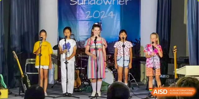 Students from Zhuhai Qiao International School performing a song on stage during the "Sundowner 2024" annual school event.