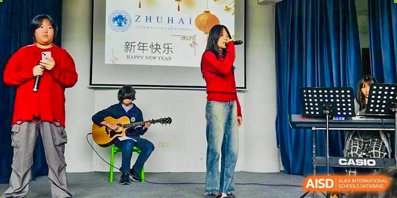 Zhuhai Qiao International School students performing during a Chinese New Year celebration, with a singer and a student playing guitar.