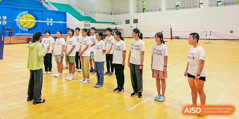 Group of Chengdu No.7 High School International Department students standing in a line in a gymnasium, wearing matching white t-shirts.