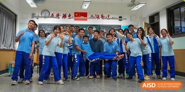 Chengdu Shishi High School Cambridge A-Level Centre students participate in a team-building activity, holding a student up on a tarp.