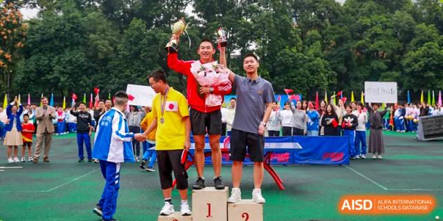 Chengdu Shishi High School Cambridge A-Level Centre students standing on a podium and holding up their trophies.