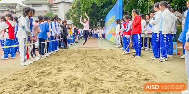 Chengdu Shishi High School Cambridge A-Level Centre students participating in a long jump or sand jump event.