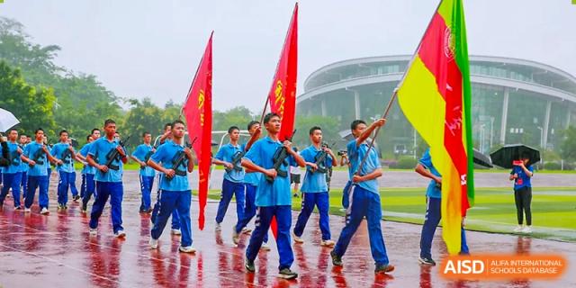 Chengdu Shishi High School Cambridge A-Level Centre students marching with flags and drumsticks.