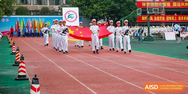 Chengdu Shishi High School Cambridge A-Level Centre students marching with a flag at a school event.