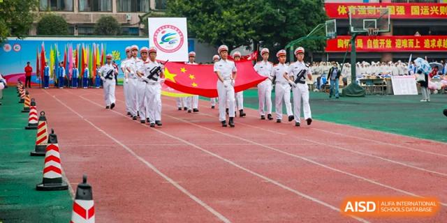 Chengdu Shishi High School Cambridge A-Level Centre students marching with a flag at a school event.