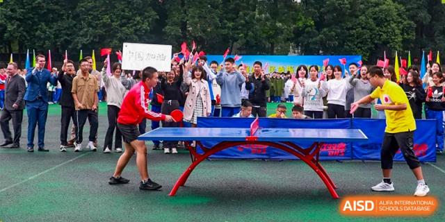 Chengdu Shishi High School Cambridge A-Level Centre students stand behind a table-tennis table.