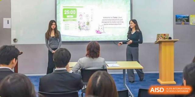 A teacher at Concordia International School Shanghai gives a presentation to students sitting in a modern classroom.