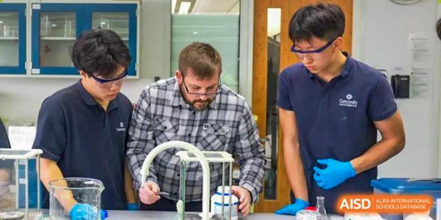 A teacher at Concordia International School Shanghai helping a student with a science experiment involving lab equipment.