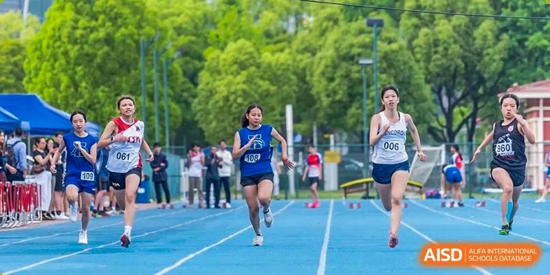 A female Concordia International School Shanghai student running down a blue track during a race.