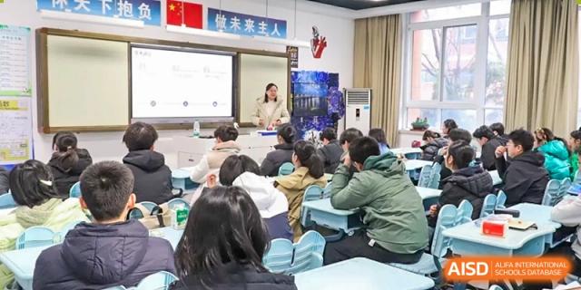 A teacher presenting in front of a large digital screen to a class full of students at the Hefei No.1 High School.