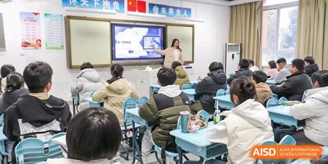 A female teacher interacting with the digital screen while teaching students seated in rows at the Hefei No.1 High School.