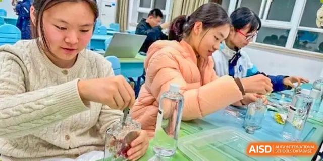 A female student conducting a science experiment using a jar and liquid, demonstrating practical learning at the  Hefei No.1 High School.