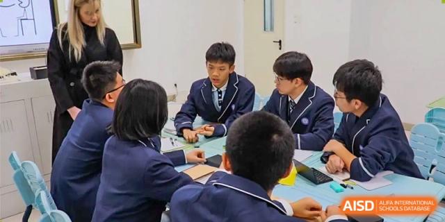Students in uniform working together in a small group on a project during class time at the  Hefei No.1 High School.