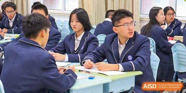 Students in uniform listening intently during a classroom lecture or group work session at the  Hefei No.1 High School.