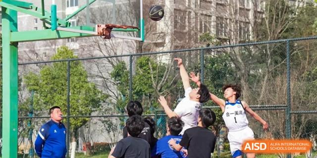 A group of students gathered around the hoop watching a teammate attempt a shot during an outdoor basketball game at the Hefei No.1 High School.