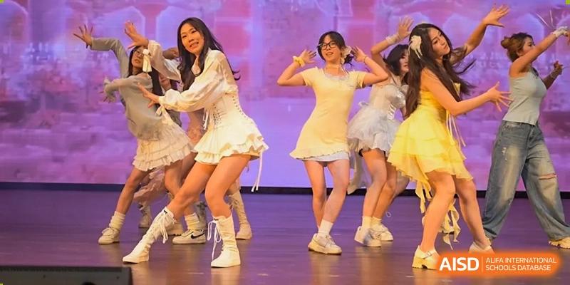 A group of female students performing a dance on stage, wearing white outfits at the Hefei No.1 High School.