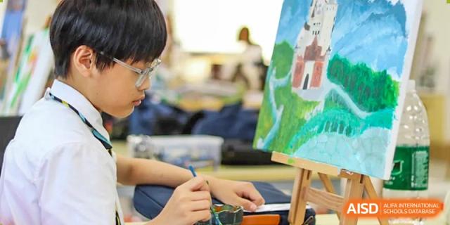 A student focused on painting on a canvas during an art class at Hiba Academy Hangzhou.