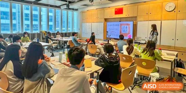 High school students attentively listening to a lecture or presentation in a classroom at Huitong School & Studios.