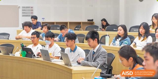 A classroom of students sitting at desks, using laptops during a lesson at Huitong School & Studios.