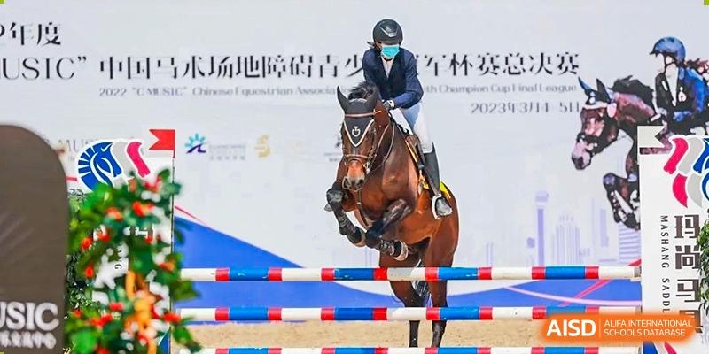 A large banner showing a rider on a horse mid-jump, participating in an equestrian event at Huitong School & Studios.