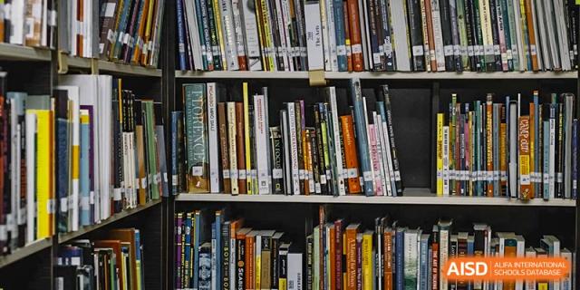 A floor-to-ceiling bookshelf filled with diverse books in the library at QSI International School of Zhuhai.