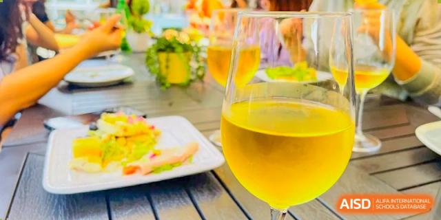 Close-up of a glass of lemonade or juice and snacks on an outdoor table, likely during a social event at QSI International School of Zhuhai.
