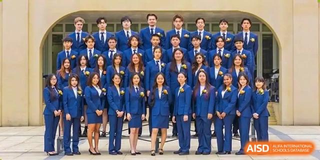 An image showing a large group of students in blue uniforms posing for a picture at Wellington College International Shanghai.