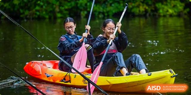 An image showing two girls paddling a canoe on the water at Wellington College International Shanghai.