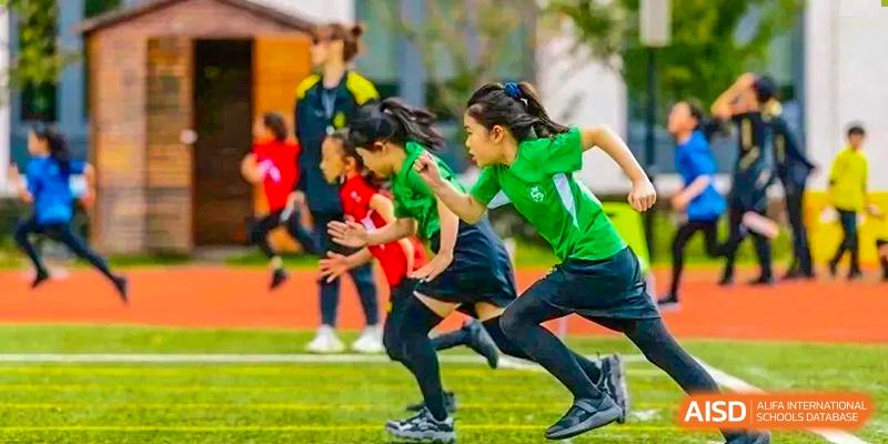 An image showing students running a race on a field at Wellington College International Shanghai.