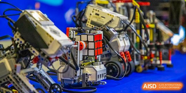 A close-up of a complex robot or engineering model built with colorful blocks and components, likely for a STEM class at Wuhan Aoxin Elite School.