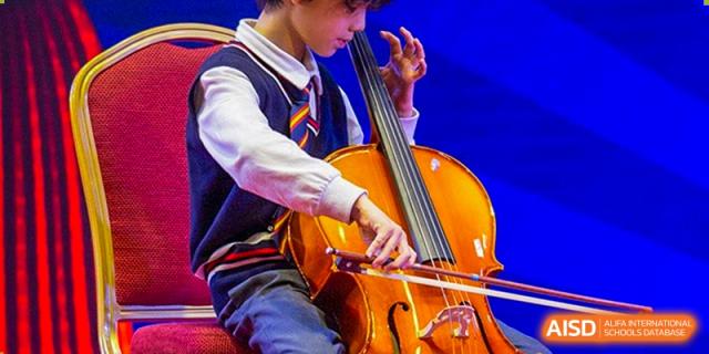 A close-up of a student playing a cello during a musical rehearsal or performance at Wuhan Aoxin Elite School.