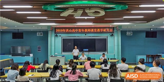Wuhan Hongshan High School International Department teaching research meeting with a lecturer at the front of a classroom.