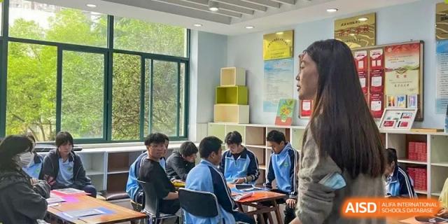 Small group of students from the Wuhan Hongshan High School International Department collaborating around a table in a bright classroom.