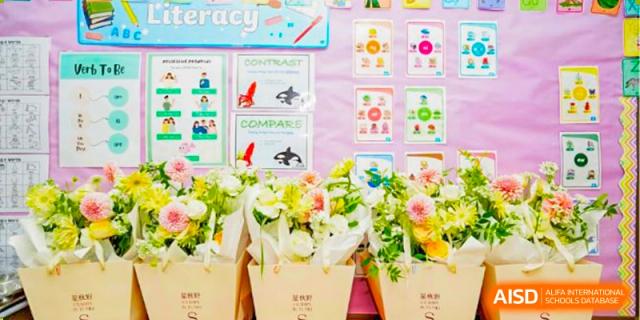A display of white flowers and educational posters about shapes and comparisons at BASIS International School Guangzhou.