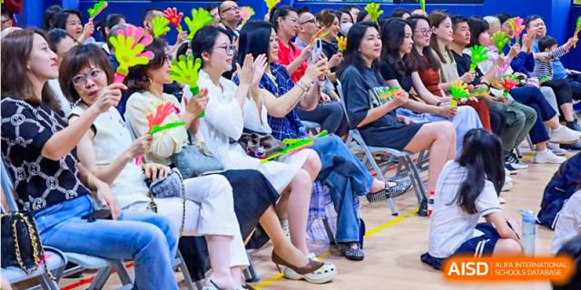 A group of adults, possibly parents or teachers, attending an event or performance at BASIS International School Guangzhou.