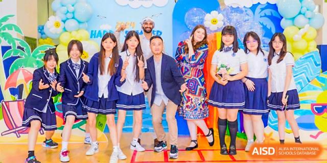 A group of students and adults posing together in front of a blue background at BASIS International School Guangzhou event.