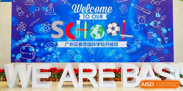A large, colorful display banner that reads "Welcome to our School" and "广州贝赛思国际学校开放日" (Guangzhou BASIS International School Open Day).