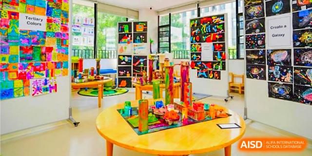 An art classroom or display area at BASIS International School Guangzhou with colorful sculptures and artwork on tables and shelves.