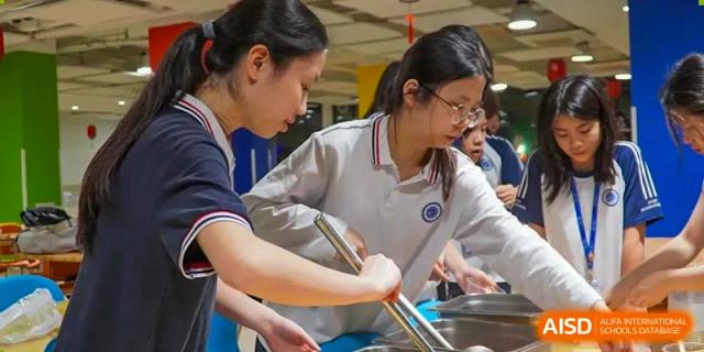A female student from BASIS International School Guangzhou mixing ingredients in a large bowl during a hands-on activity.