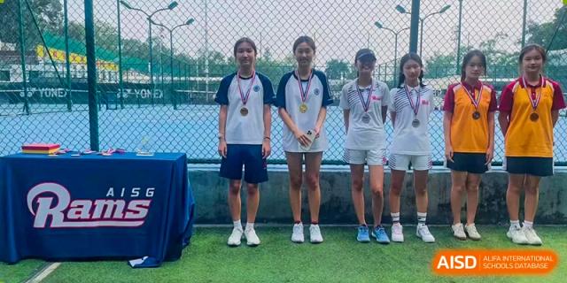 Three female students from BASIS International School Guangzhou wearing medals while standing together after a sports competition.