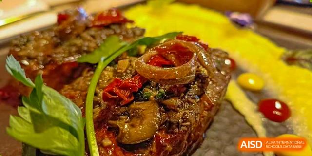 A gourmet dish of meat and mushrooms topped with sautéed onions and peppers served at BASIS International School Guangzhou.