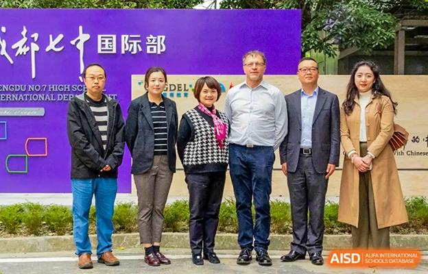 Group photo of Chengdu No.7 High School International Department faculty and guests, including two Western men, standing outside.