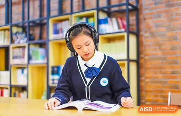 Chengdu No.7 High School International Department student in uniform reading a book and wearing headphones in the school library or study area.