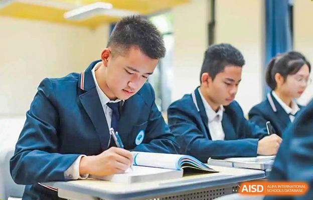 Chengdu No.7 High School International Department students in school uniforms focusing intently on their schoolwork during class.