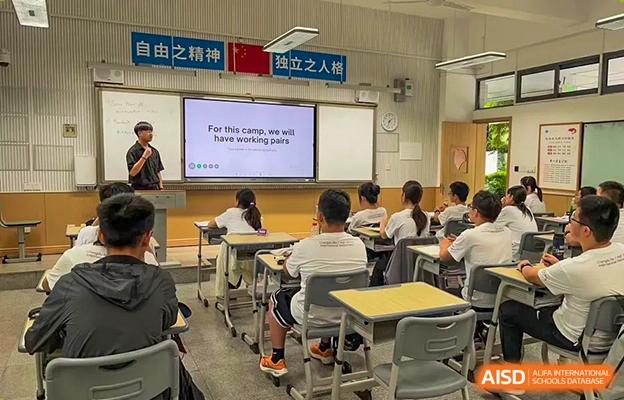 Classroom at Chengdu No.7 High School International Department with students seated at desks and a motivational message displayed on the screen.