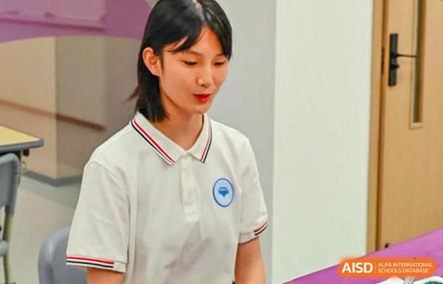 Portrait of a female student from the Chengdu No.7 High School International Department in a white polo shirt, speaking or presenting.