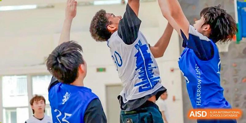 A student from Harrow International School Beijing (AISL Beijing) is shooting a basketball during a game in the gym.
