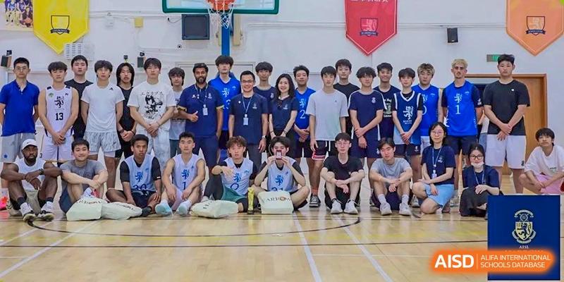 The Harrow International School Beijing (AISL Beijing) sports teams are posing together for a group photo in the gymnasium.